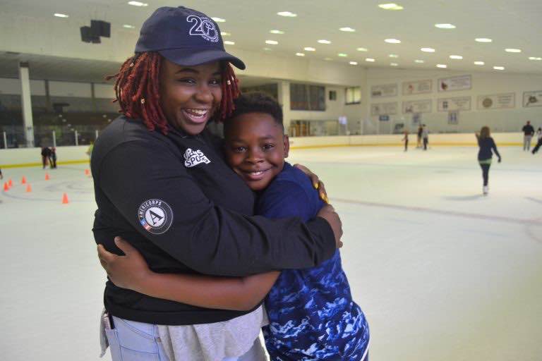 Kids on Ice holding onto one another